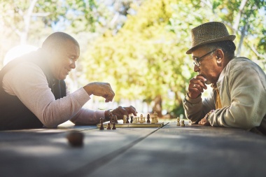 older men outside playing chess representing retirement strategies